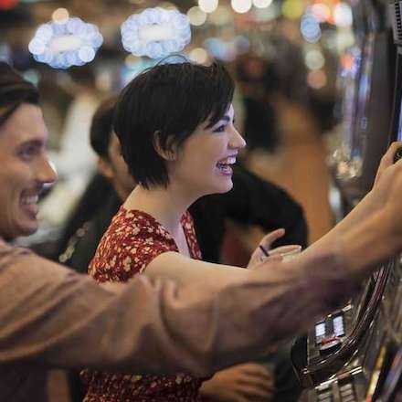 Photo of people playing at the slot machines.