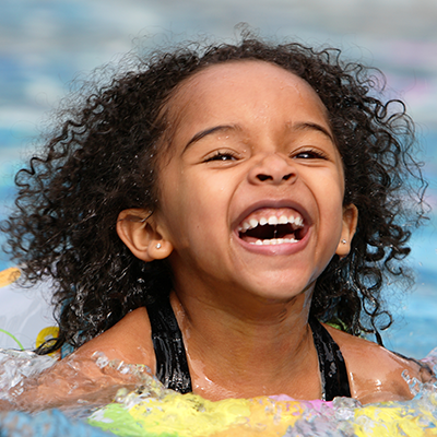 Photo of young girl smiling in a pool