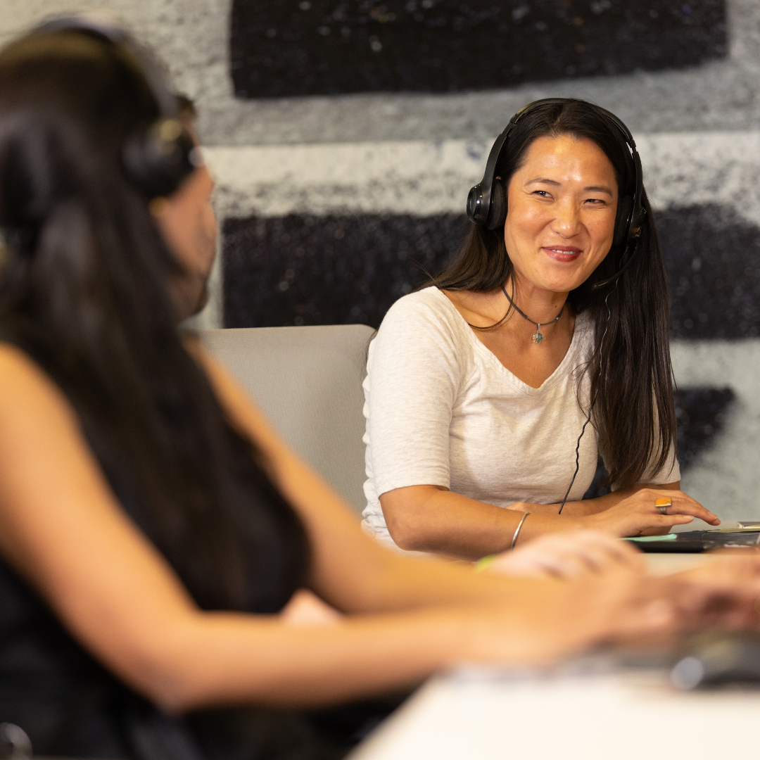 Woman smiling at other coworker at desk