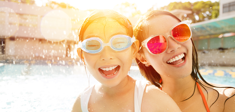 Two girls smiling by the pool