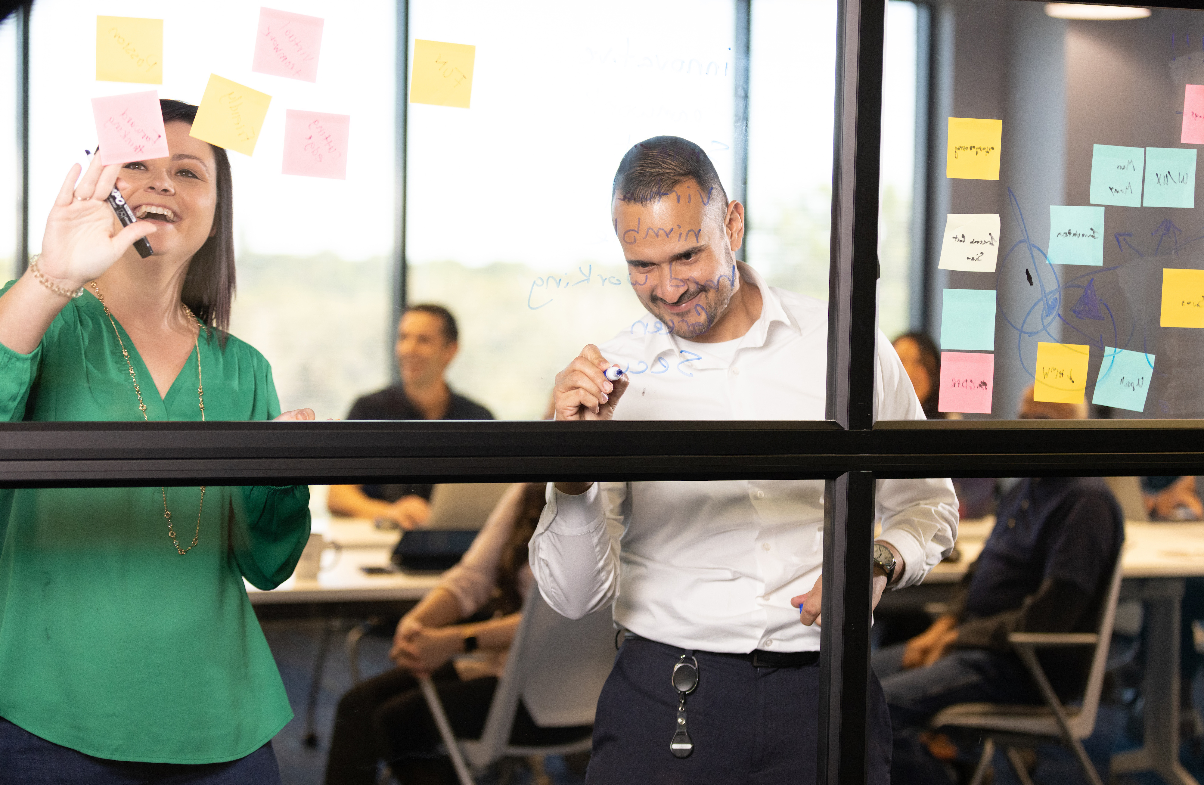 Man and woman drawing on whiteboard