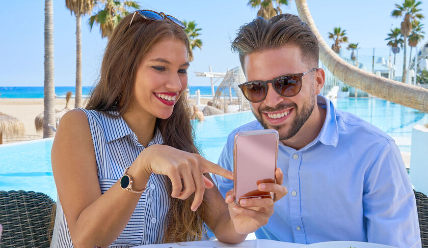 Couple sitting outside by the pool having lunch at a beautiful resort
